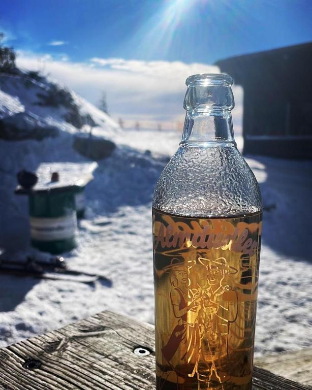 a bottle of alcohol sitting on a table in the snow at Panorama Lodge Hohegeiß Sport und Erholung im Harz in Braunlage