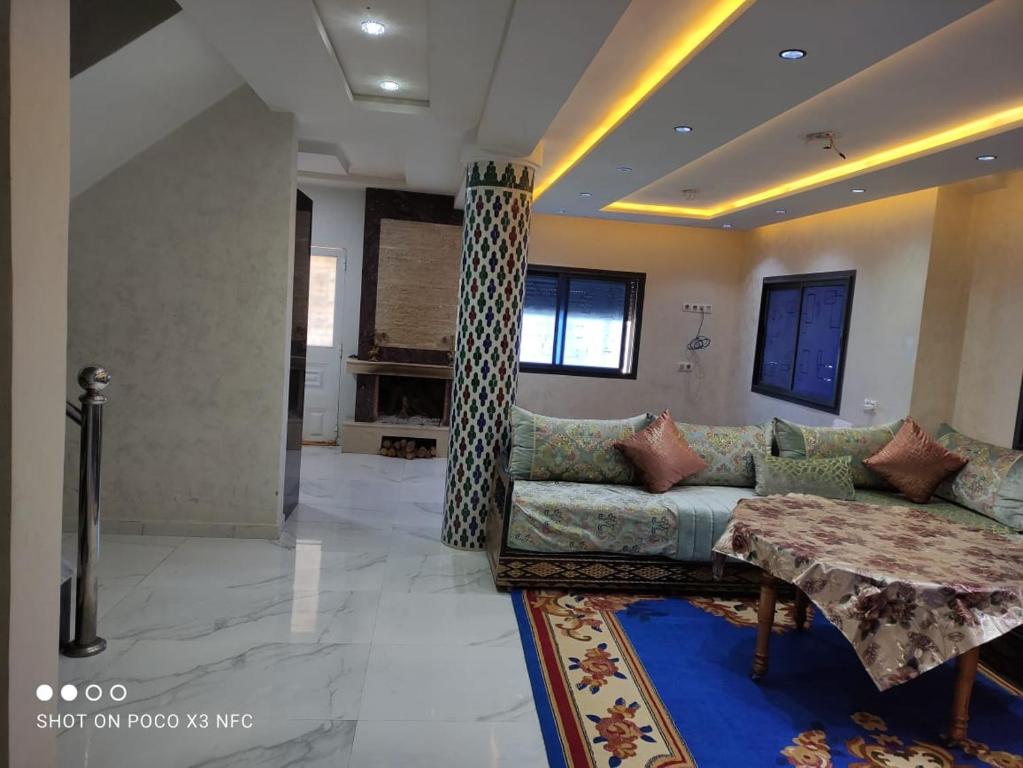 sala de estar con sofá y mesa en Super Chalet à Imouzzer kendar., en Imouzzer Kandar