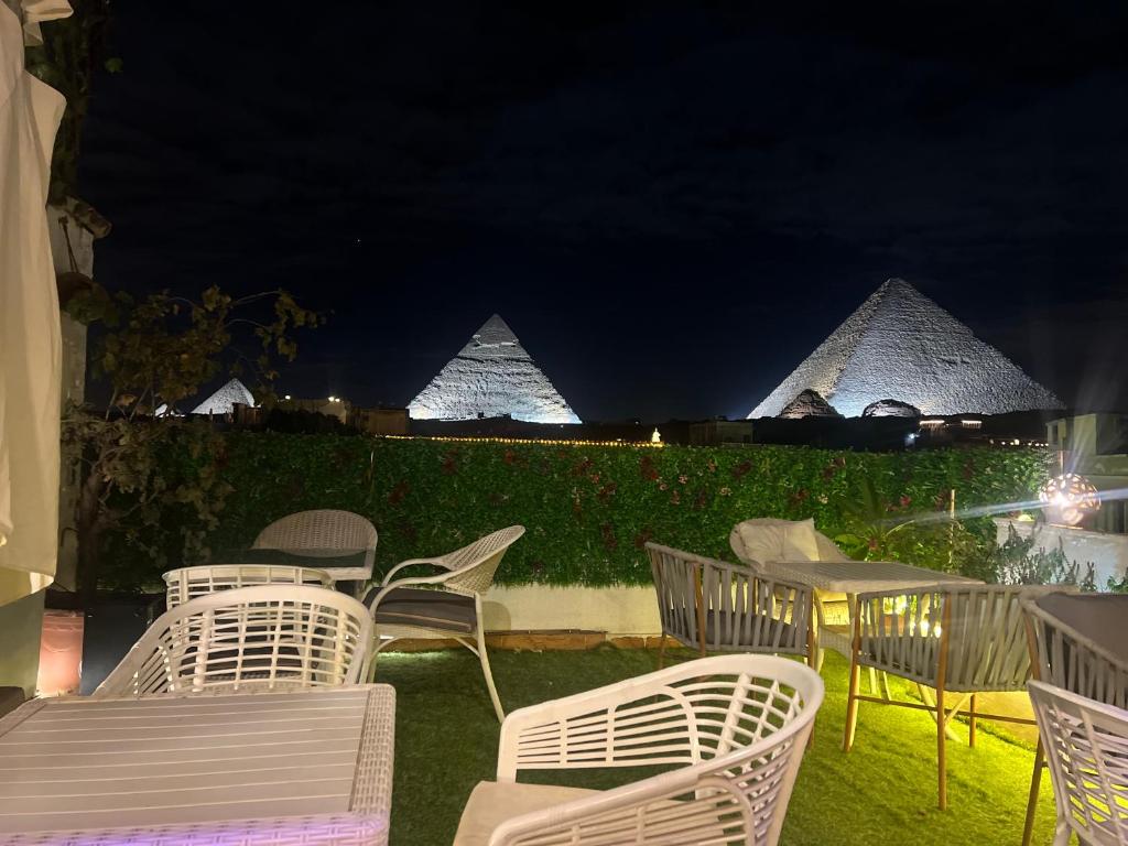 un gruppo di sedie e tavoli con piramidi sullo sfondo di PYRAMIDS TOP IN a Il Cairo