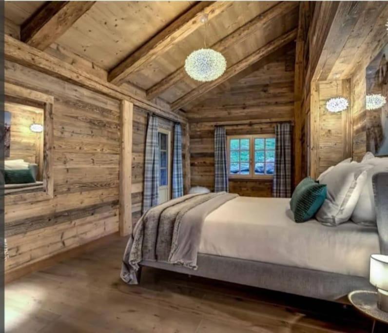 una camera da letto con pareti in legno e un grande letto di Chalet de L'Ours Blanc a Saint-Gervais-les-Bains