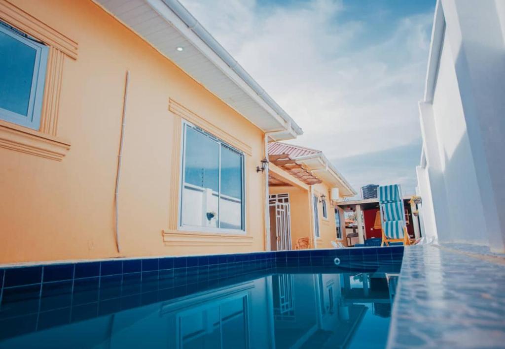 a swimming pool next to a house with a building at Heavenly ApHEARTment with backyard swimming pool in Dodoma