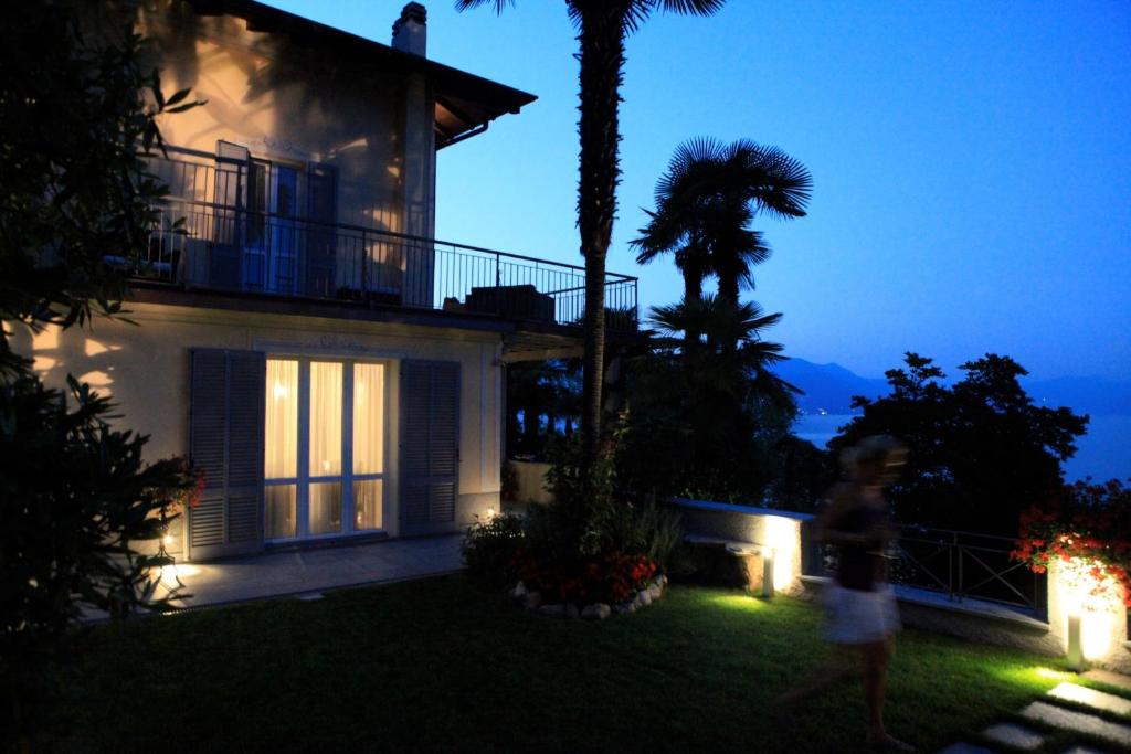 a woman walking in front of a house at night at Villa Vignolo in Stresa