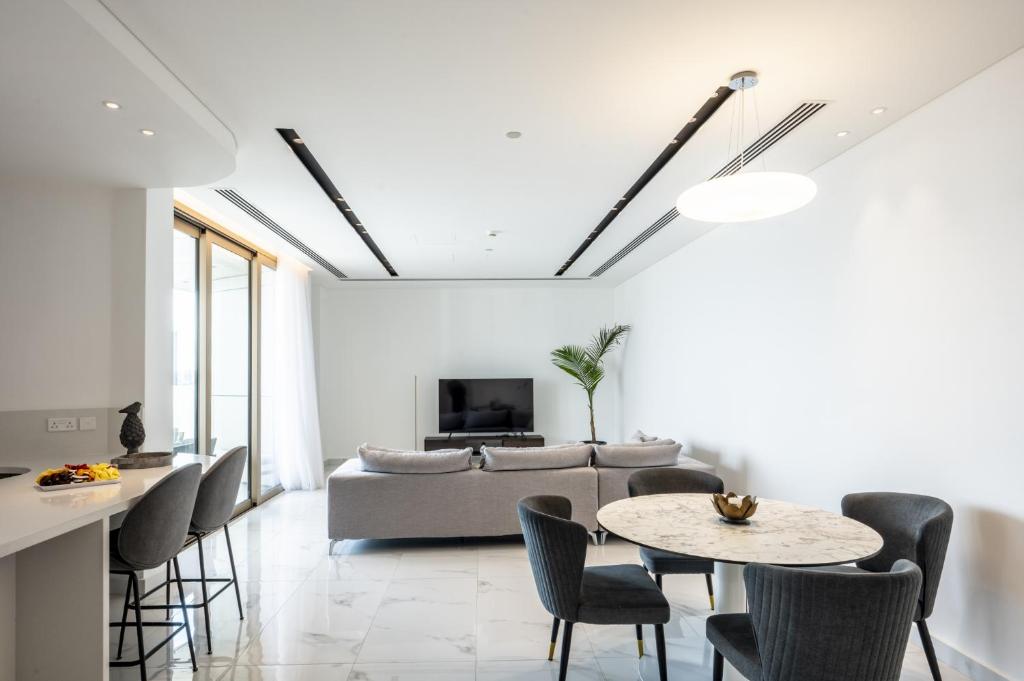 a living room with a couch and a table and chairs at 360 Nicosia - 2 bedrooms Luxury Residence in Nicosia
