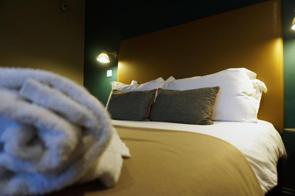 Schlafzimmer mit einem Bett mit weißer Bettwäsche und Kissen in der Unterkunft The Penny Farthing Hotel in Berkhamsted