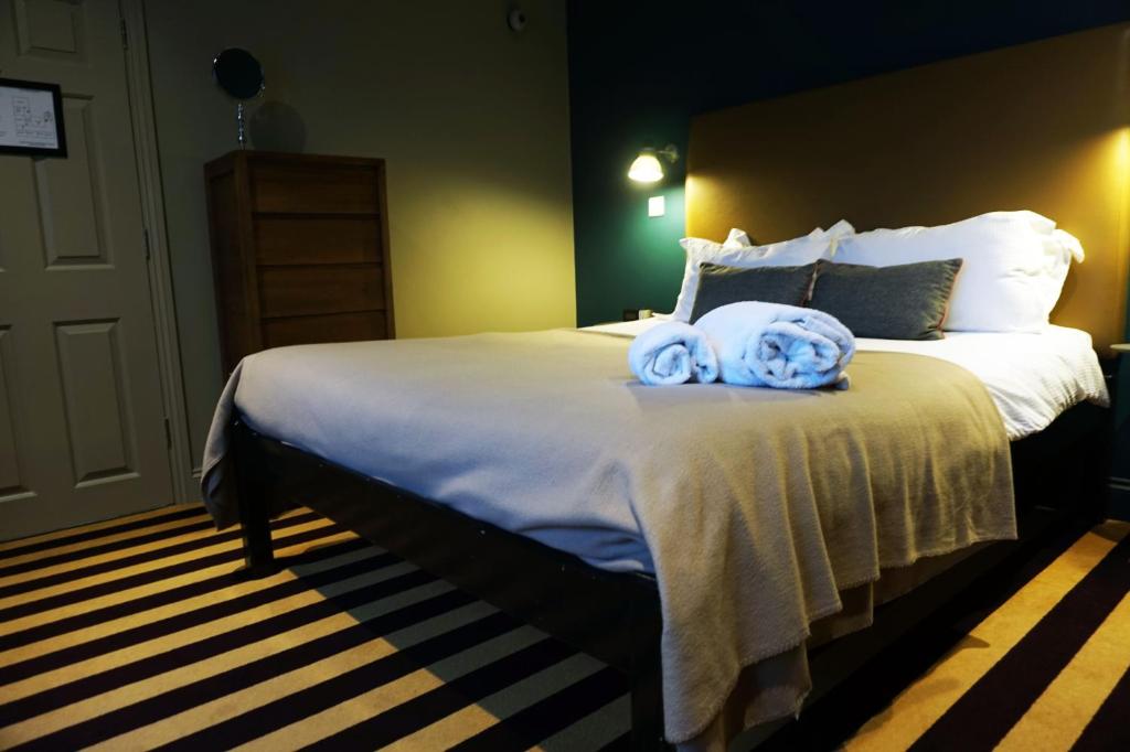 a bedroom with a large bed with towels on it at The Penny Farthing Hotel in Berkhamsted