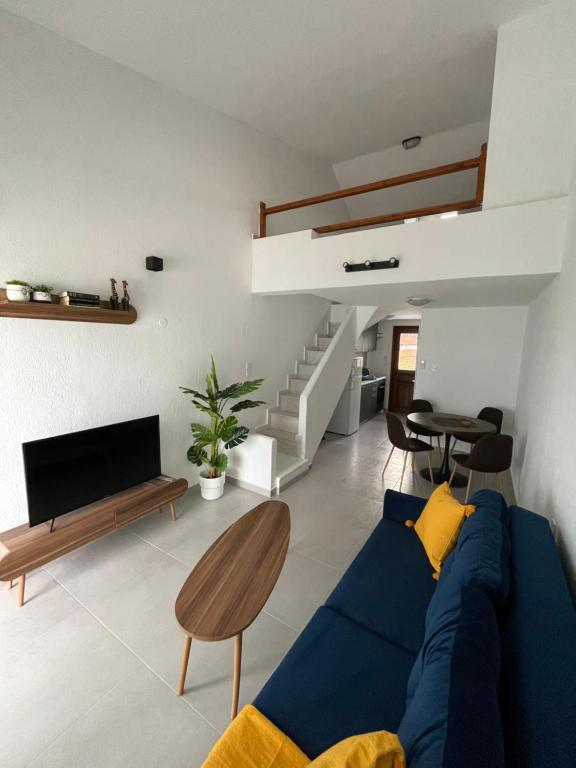 a living room with a blue couch and a tv at Sea View Loft in Nea Roda