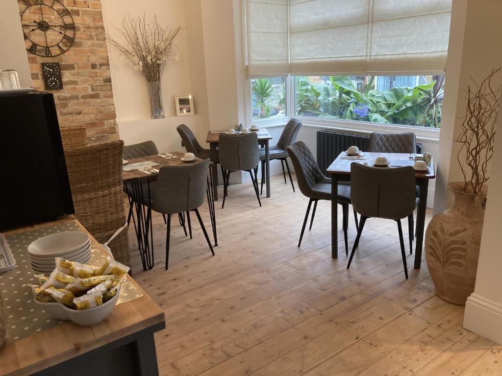 a dining room with tables and chairs and a window at Summer Breeze in Newquay