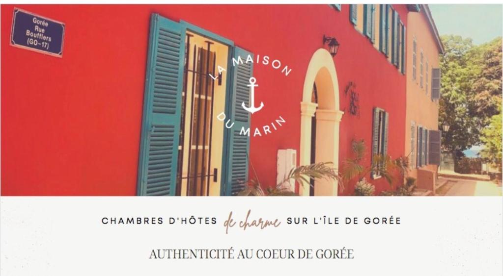 a picture of a red building with a sign on it at La Maison du Marin in Gorée