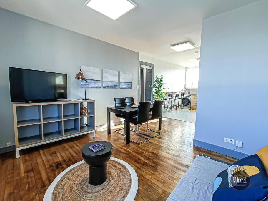 uma sala de estar com uma televisão e uma mesa e cadeiras em Appartement calme lumineux proche gare 3 chambres em Angoulême