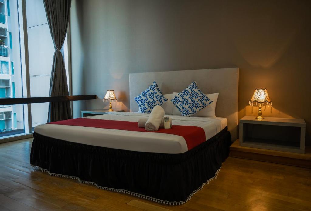 a bedroom with a large bed with two lamps at La Platinum KLCC in Kuala Lumpur