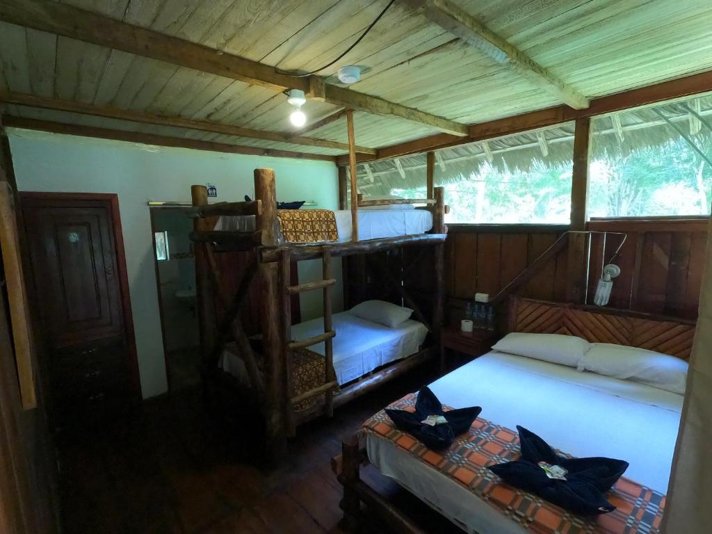 a bedroom with two beds and a wooden ceiling at Isla Ecologica Mariana Miller in Puerto Misahuallí