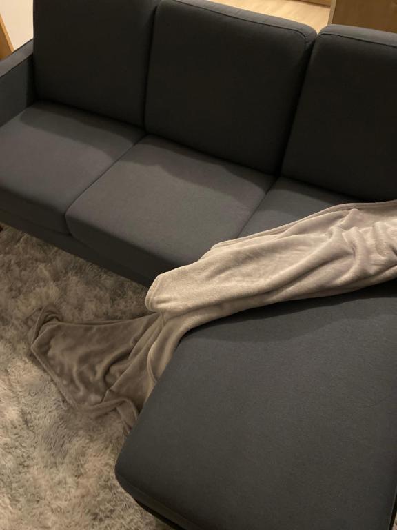 a couch with a blanket laying on the floor at Somie in Lille