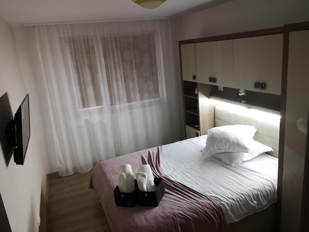 a bedroom with a bed with two pairs of shoes on it at Alexandra view studio in Braşov