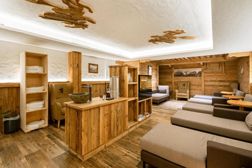 un soggiorno con pareti in legno e una camera con divani di Hotel Restaurant Hexenalm a Söll