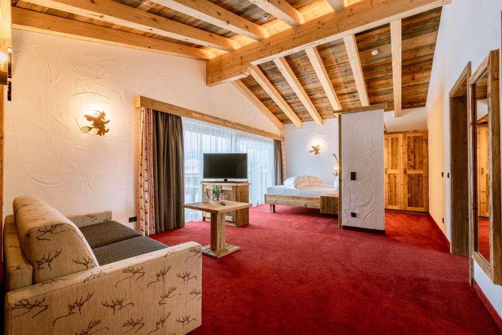 un soggiorno con divano e letto di Hotel Restaurant Hexenalm a Söll