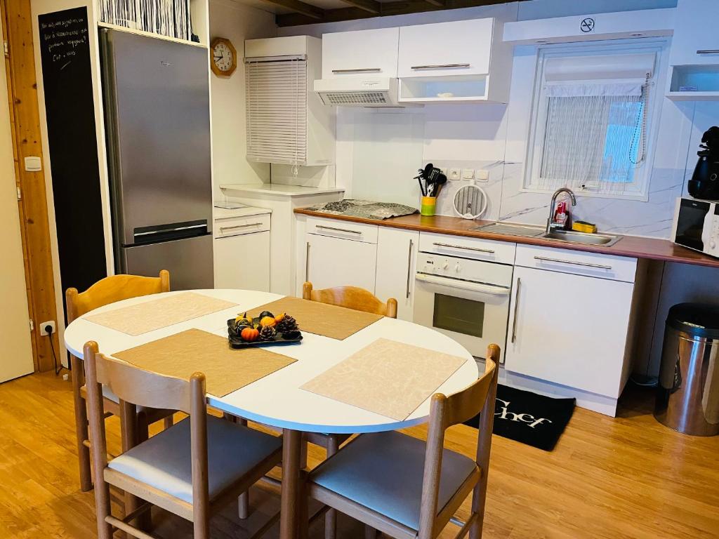 kuchnia ze stołem i krzesłami w kuchni w obiekcie Le 77 - chalet nature proche S.Besse w mieście Égliseneuve-dʼEntraigues