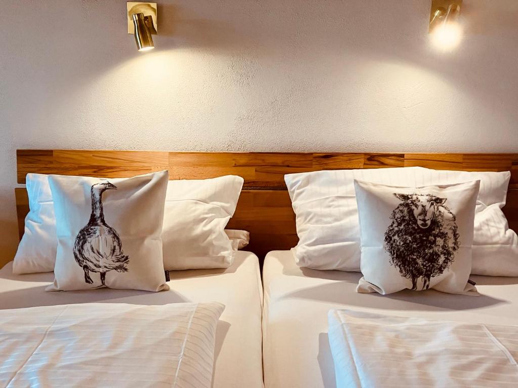 2 Betten mit Kissen mit Vogel drauf in der Unterkunft Alpenflair Ferienwohnung 102 Frohnatur in Oberstdorf
