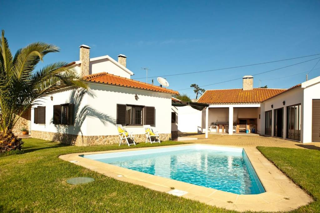 una piscina di fronte a una casa di Spacious and family friendly villa at Lisbon coast 