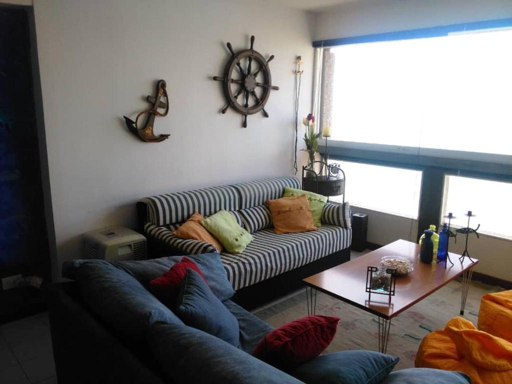 een woonkamer met een bank en een tafel bij Acogedor apartamento con piscina - Bleu Marine Suites in La Guaira