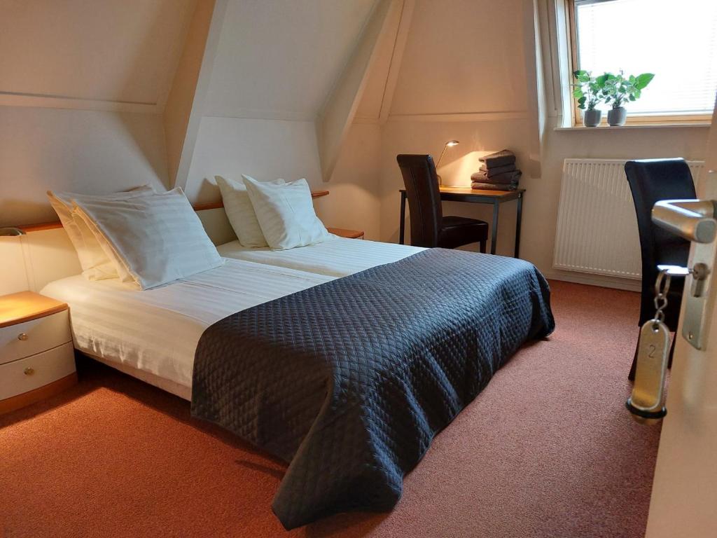 Boetiek Hotel Marum في Marum: غرفة نوم بسرير كبير في غرفة