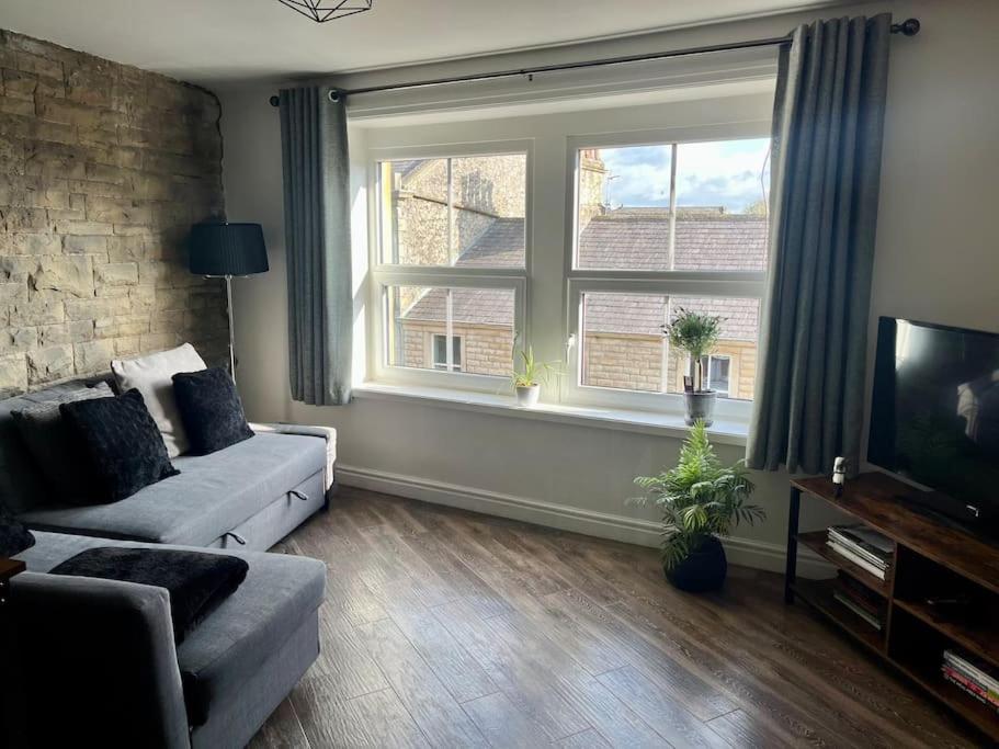 a living room with a couch and a large window at Boutique penthouse apartment with rooftop terrace in Clitheroe