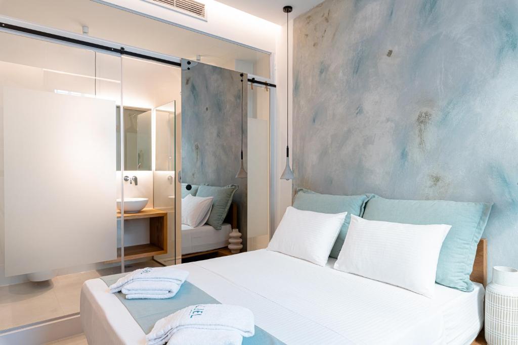 a bedroom with a white bed and a mirror at Ciel Suites Athens in Athens
