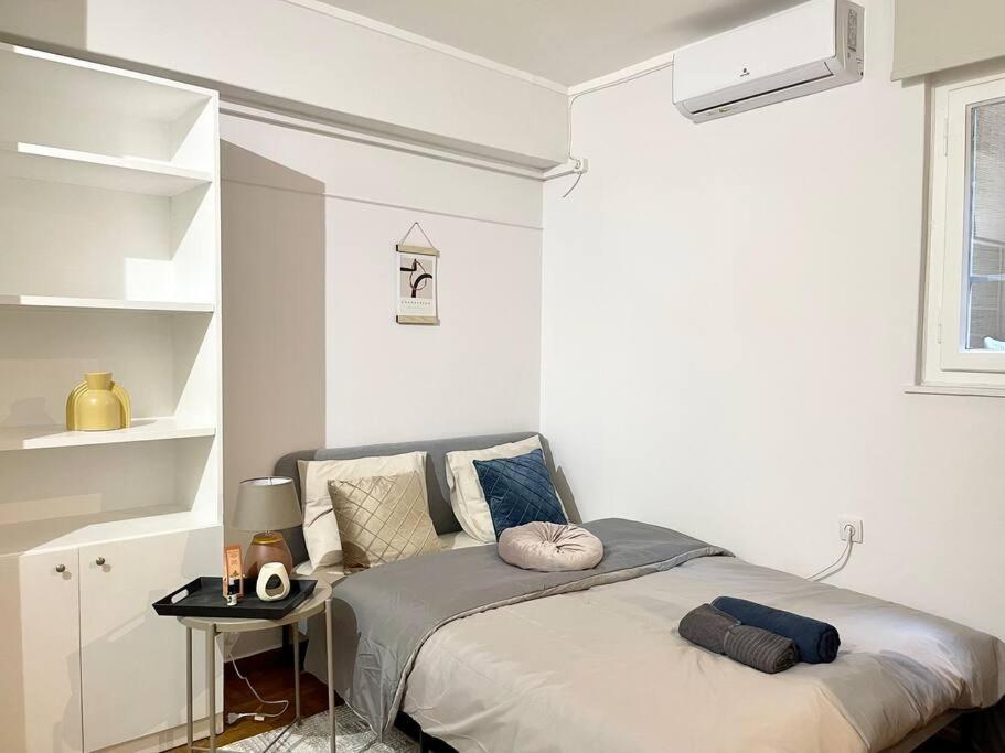 um quarto com uma cama num quarto branco em The Love Nest at Central Athens Kolonaki em Atenas