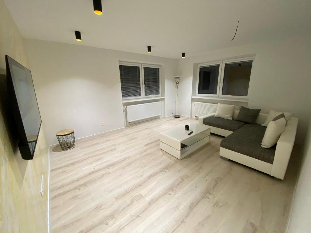 a living room with a couch and a flat screen tv at Apartman M&M in Žilina