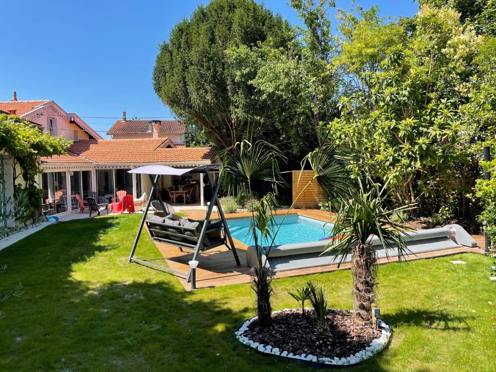 a swimming pool in a yard with two trees at Mérig'home Chambre BD climatisée dans maison avec piscine au calme en ville, SdB & toilettes privés in Angoulême