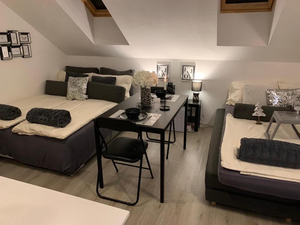 uma sala de estar com um sofá, uma cama e uma mesa em Apartment Mansarda em Maribor