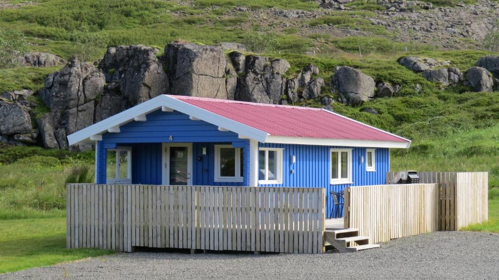 a blue tiny house with a red roof at Hvammur 4 with private hot tub (Fagurgali) in Drangsnes