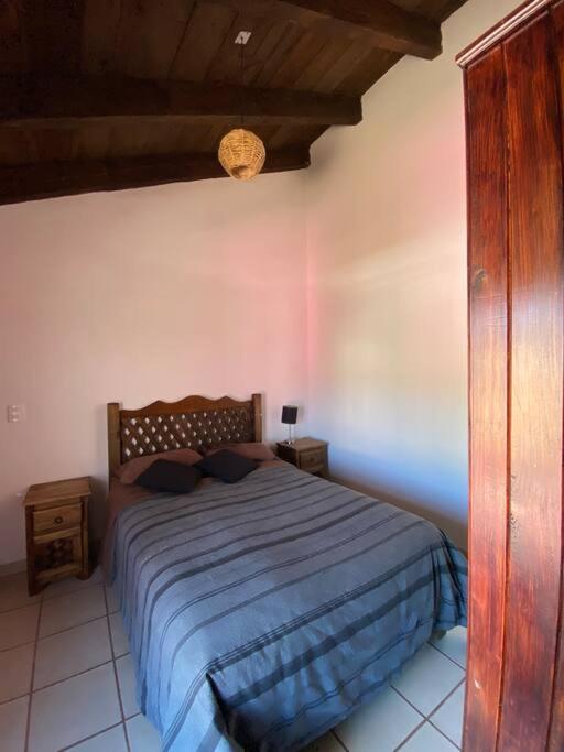 a bedroom with a bed with a blue comforter at Happy Place in San Cristóbal de Las Casas