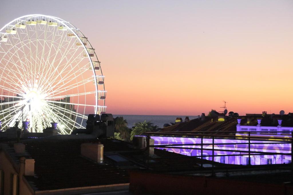 une roue ferris devant un coucher de soleil dans l'établissement Duplex lumineux et spacieux, à Nice