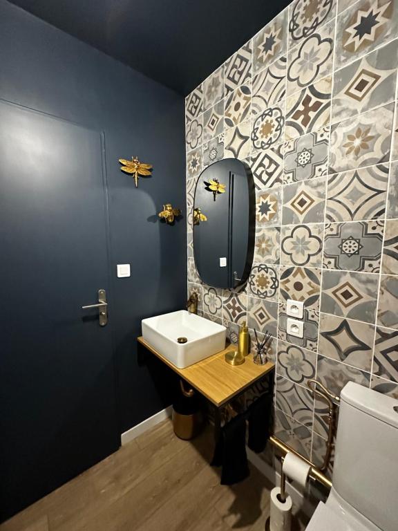 a bathroom with a sink and a mirror at LES TEMPS HEUREUX exclusivement Familles in Quimper