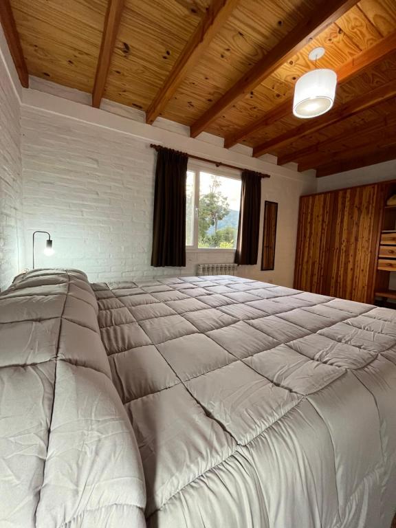 Las Liebres Casa de Montaña في الهويو: سرير أبيض كبير في غرفة بها نافذة