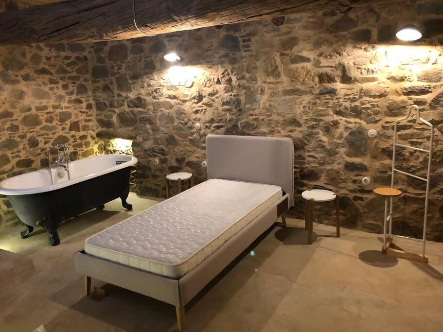 um quarto com uma cama, uma banheira e um lavatório em Lemon's Cottage House, Volissos, Chios em Volissos