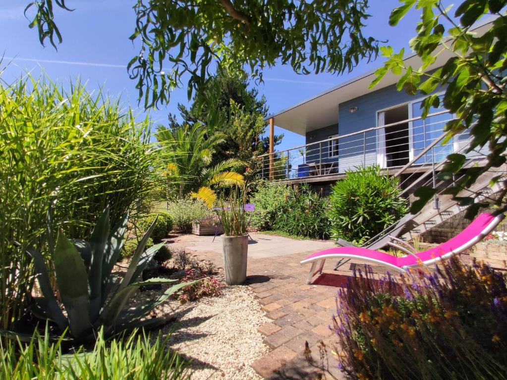 un giardino con panchina e una casa di CHALET DE L'EPINETTE a Plourhan