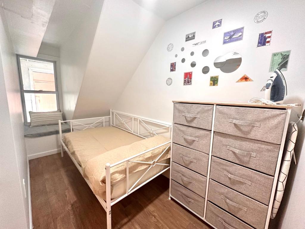 a small bedroom with a bed and a dresser at Classical Isbills Row House close to NYC in Bayonne