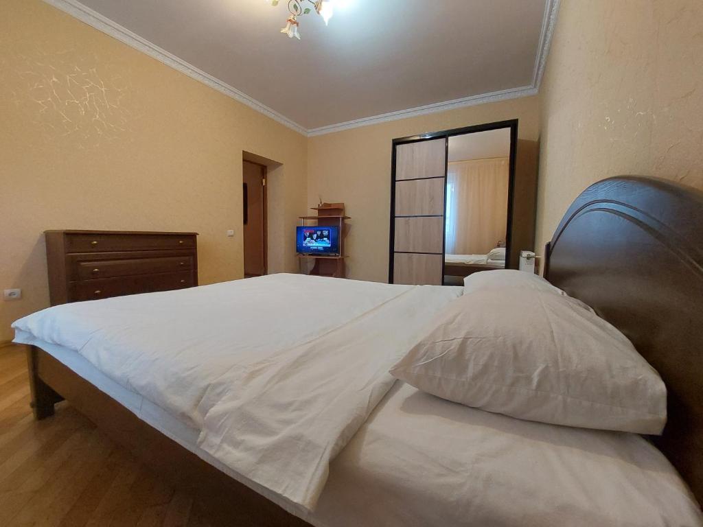 Schlafzimmer mit einem großen weißen Bett mit einem schwarzen Kopfteil in der Unterkunft Однокімнатна біля автостанції, вулиця Зацепи in Luzk