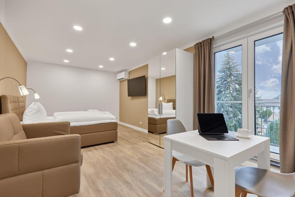 a room with a bed and a desk with a laptop at Boardinghotel Premium Heidelberg in Heidelberg