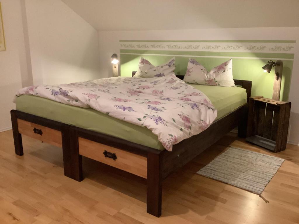 a bedroom with a large bed with a green headboard at Gemütliche, großzügige Ferienwohnung in Salzhausen