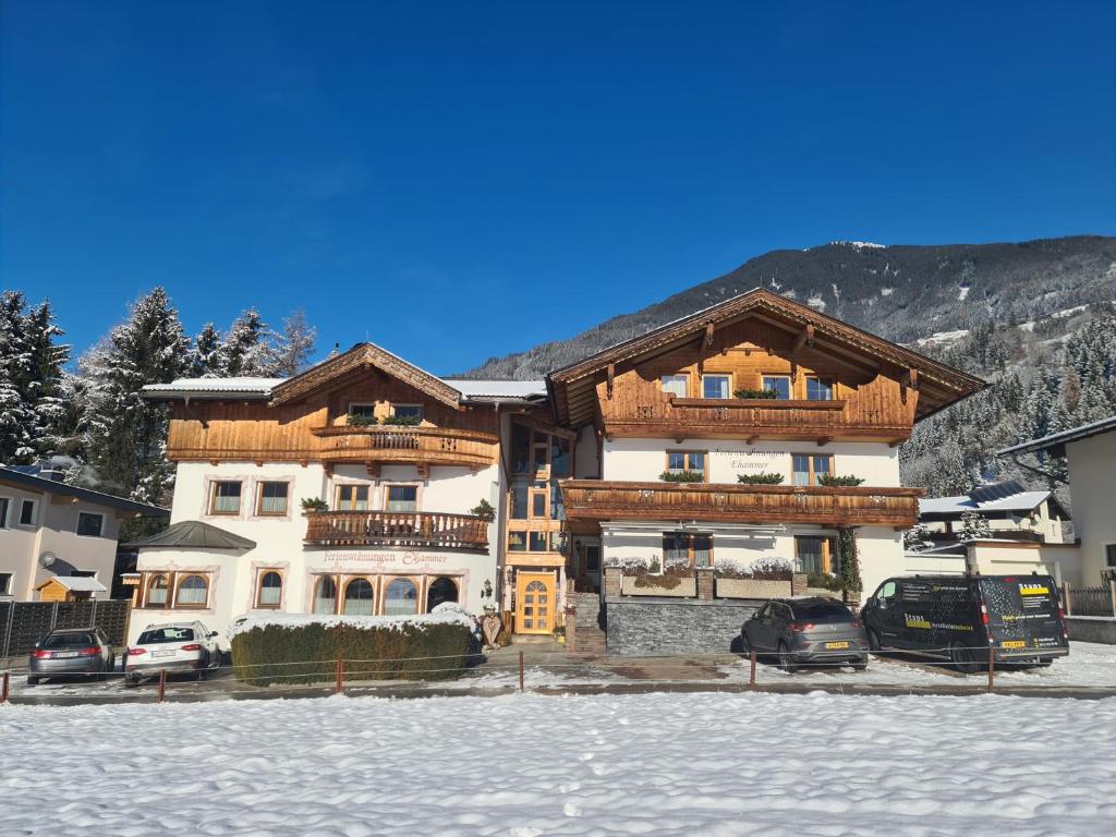 un gran edificio con coches estacionados frente a él en Ferienwohnungen Ehammer, en Stumm