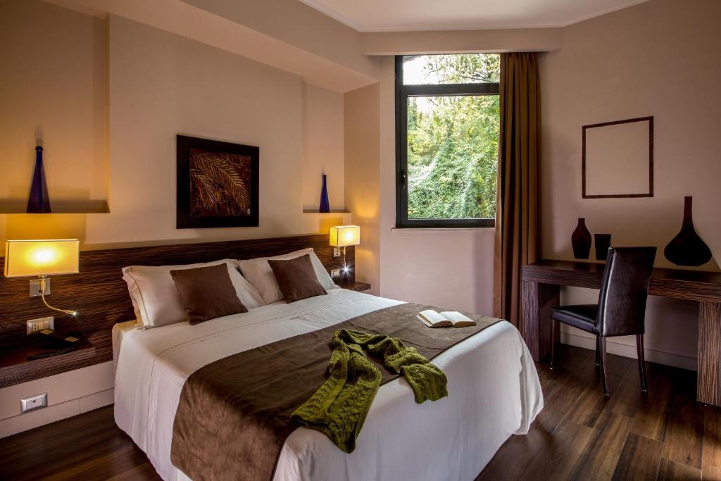 Schlafzimmer mit einem Bett, einem Schreibtisch und einem Fenster in der Unterkunft Park Hotel Sabina in Magliano Sabina