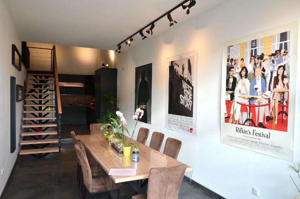 comedor con mesa de madera y sillas en Loft industriel dans une ancienne grange 