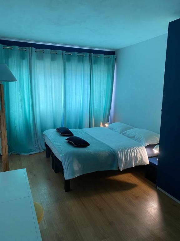 een slaapkamer met een bed met een blauw licht bij Le Rayon Vert in Le Touquet-Paris-Plage