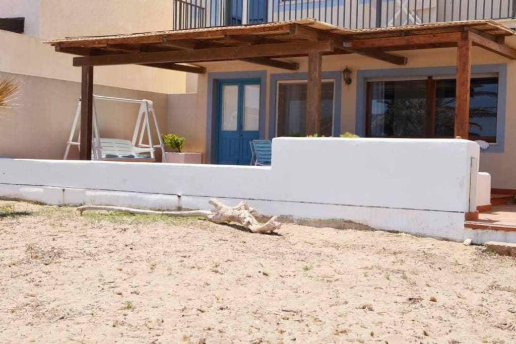 een huis met een wit hek ervoor bij Casa delle Palme sulla spiaggia in Marzamemi