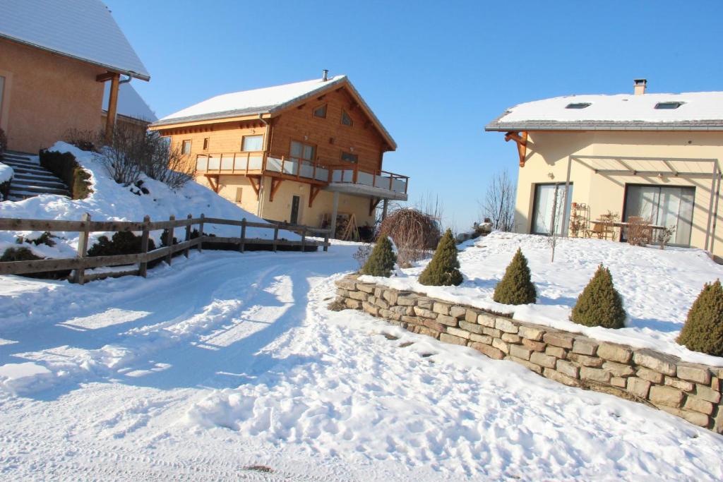 um quintal coberto de neve com uma casa e um edifício em ANCELLE TAILLAS RDC CHALET em Ancelle
