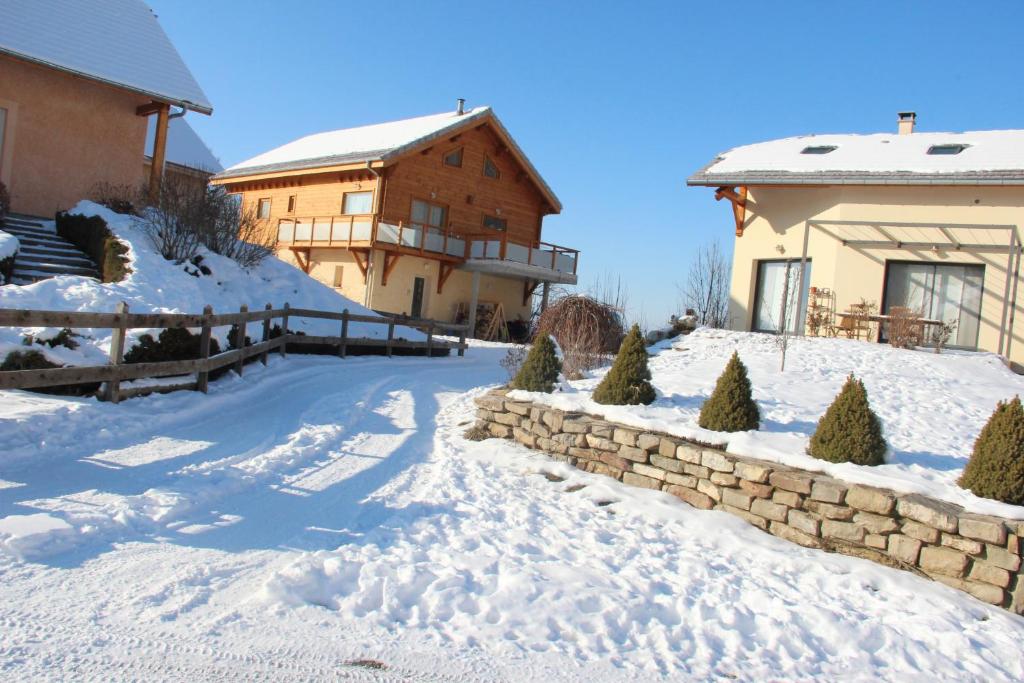 une cour enneigée avec une maison et un bâtiment dans l'établissement ANCELLE TAILLAS RDC CHALET, à Ancelle