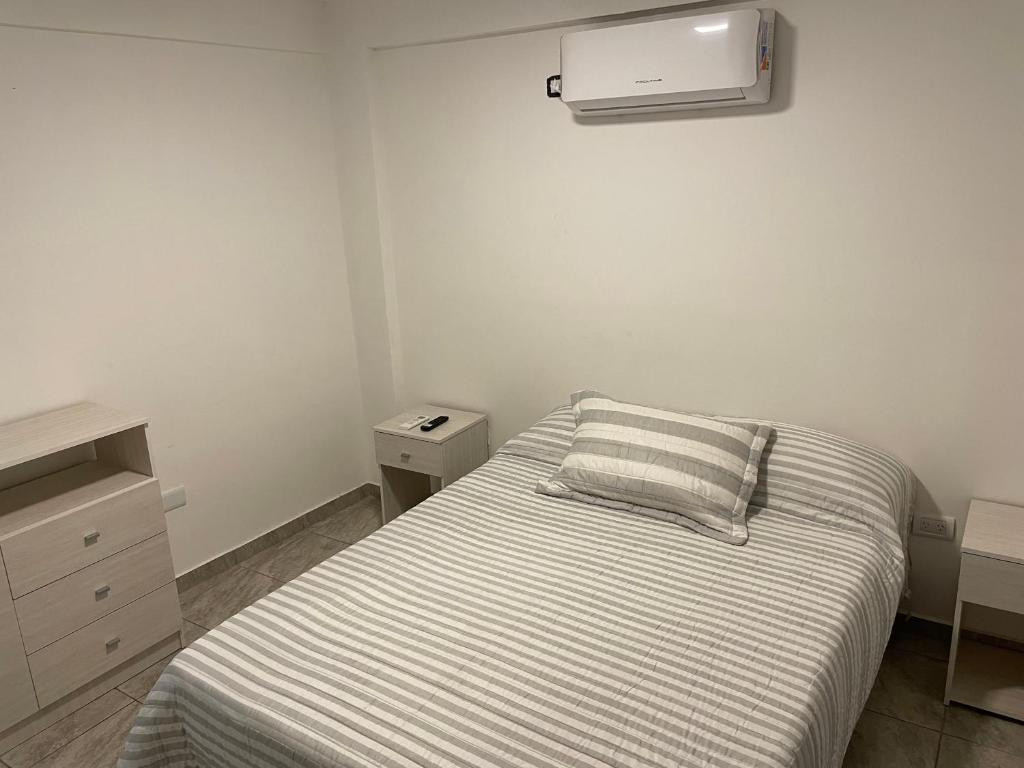 Dormitorio pequeño con cama y aire acondicionado en Azul en Córdoba