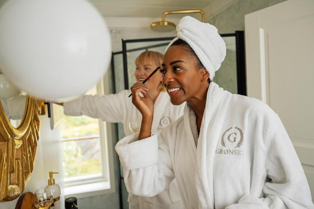 a woman brushing a childs teeth in front of a mirror at Grønset Skysstasjon in Vinjeøra